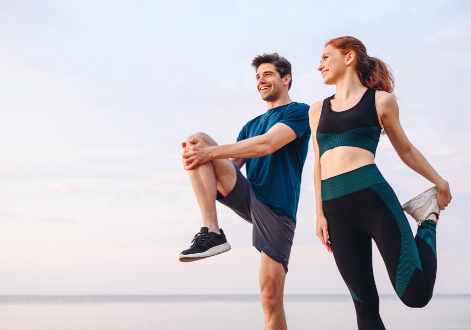 Lower couple young two friend strong sporty sportswoman sportsman woman man in sport clothes warm up training do stretch exercise on sand sea ocean beach outdoor jog on seaside in summer day morning